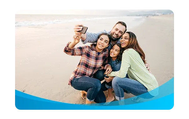 family with cell phone on the beach